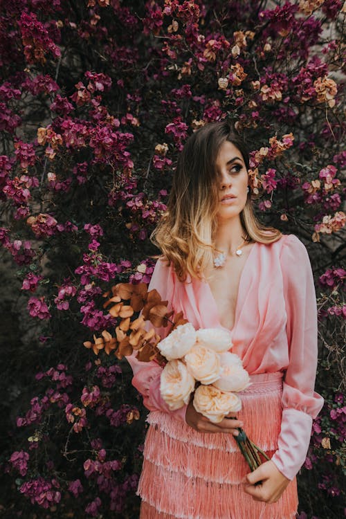 Photo of Woman Standing in Front of Flowers