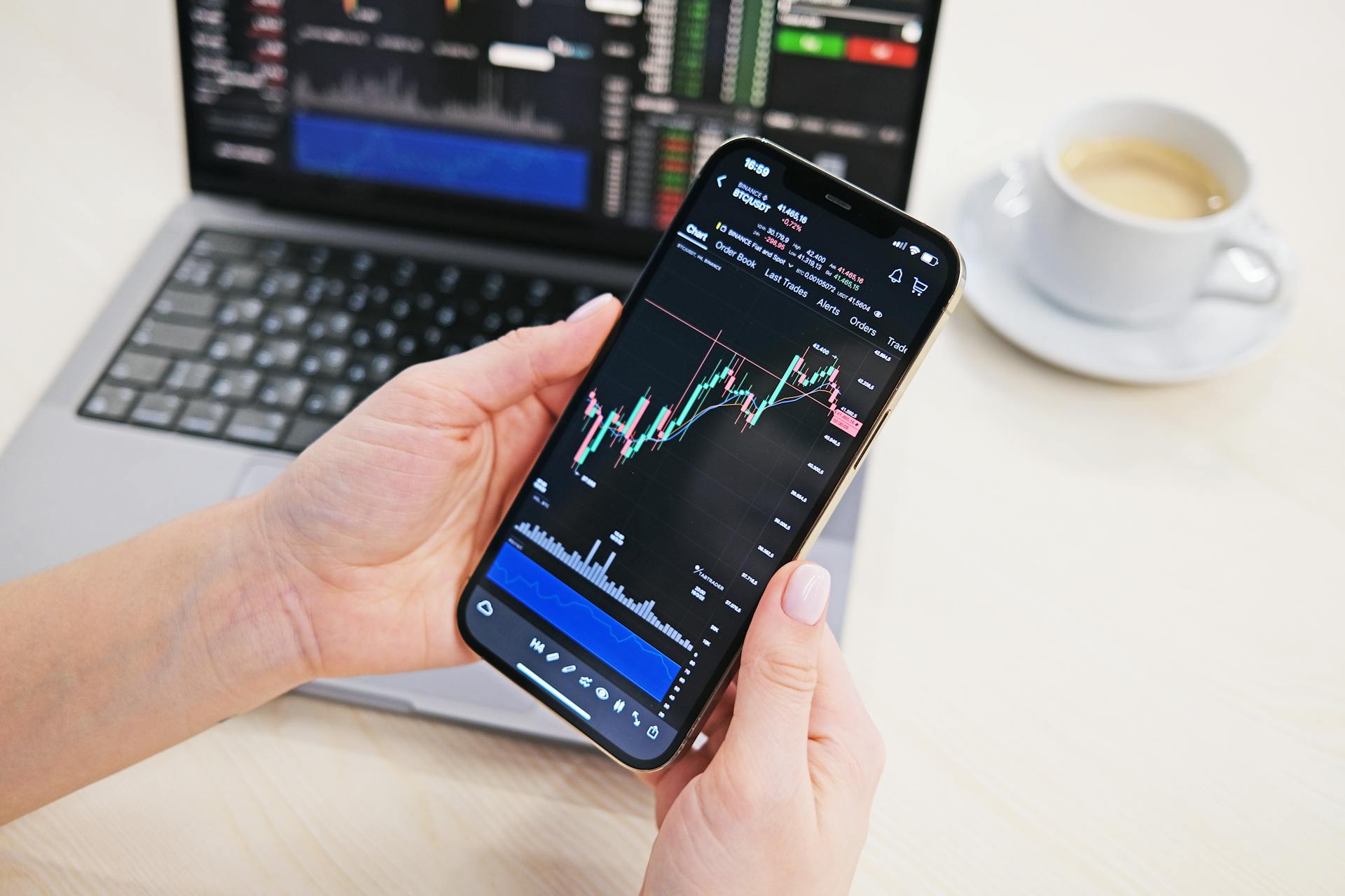 Close-up of a Person Holding a Smartphone Displaying a Cryptocurrency Chart