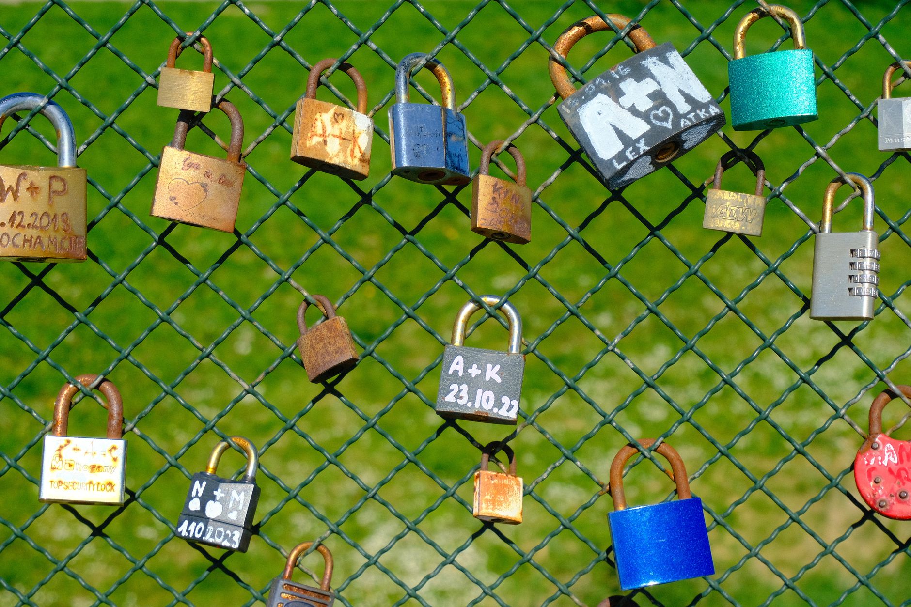 Colorful love padlocks on a mesh fence symbolizing connection and protection.