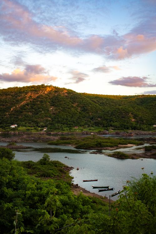 Free A tranquil scene of a lake surrounded by lush mountains at sunset, perfect for nature wallpapers. Stock Photo