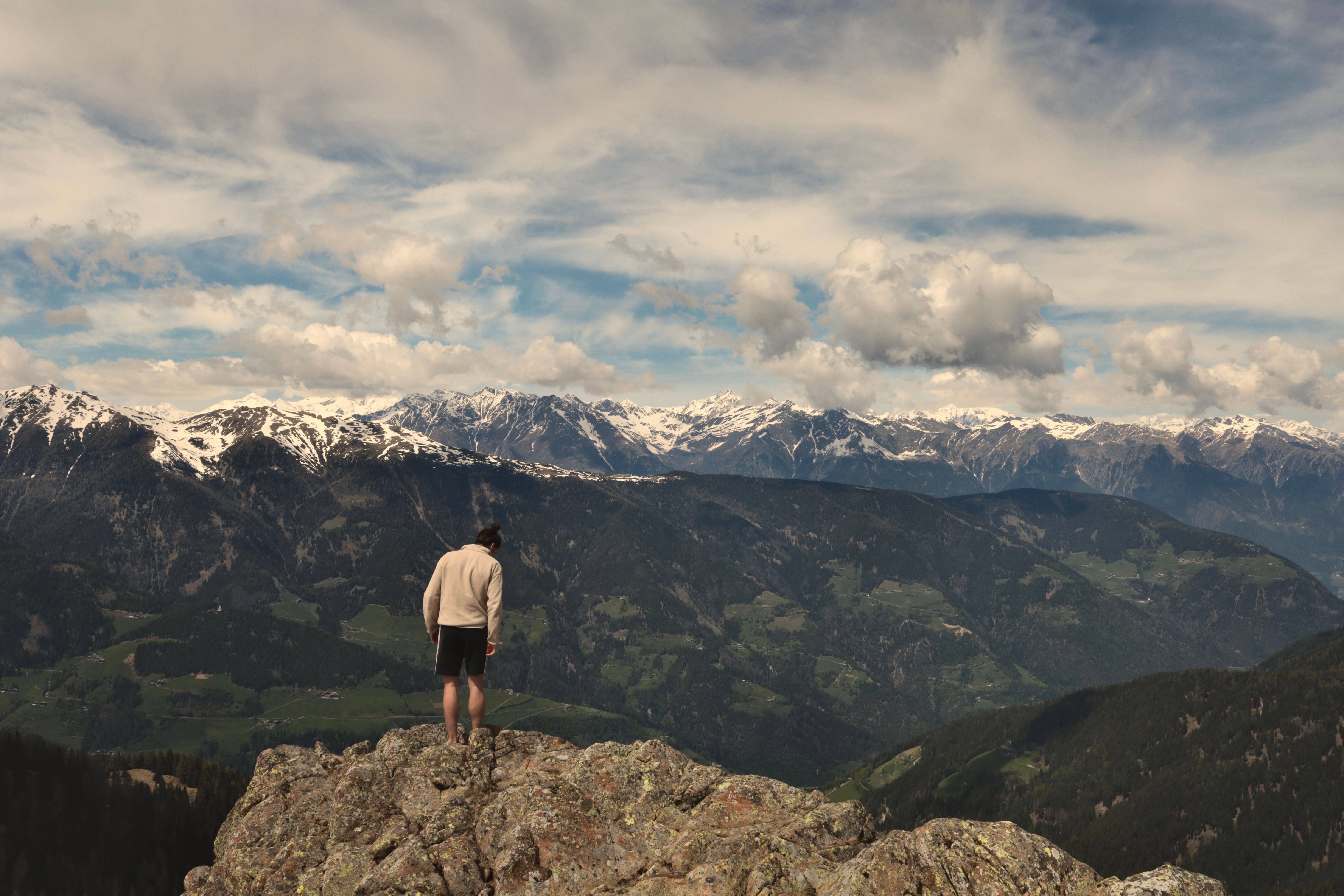 Man Standing on a Rock Against Mountain Landscape · Free Stock Photo