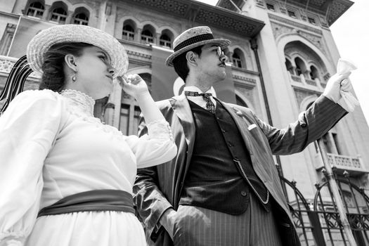 Black and white photo of a well-dressed vintage couple in front of iconic Ankara architecture.