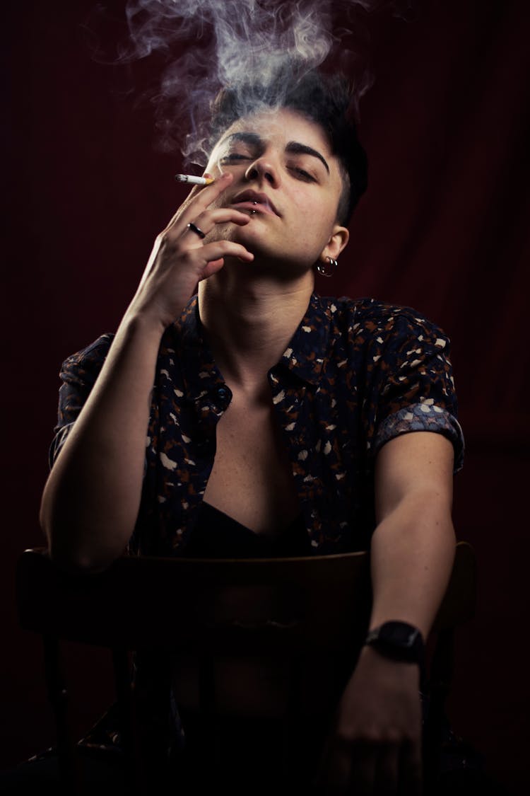 Photo Of Person Smoking While Sitting On Chair