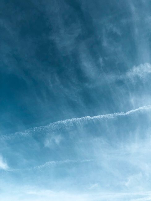 Bright blue sky with wispy clouds, creating a serene and open atmosphere, perfect for backdrop use.