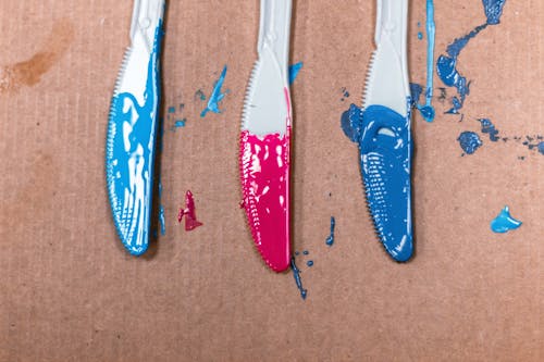 Фото акриловых красок, нанесенных на три стальных ножа