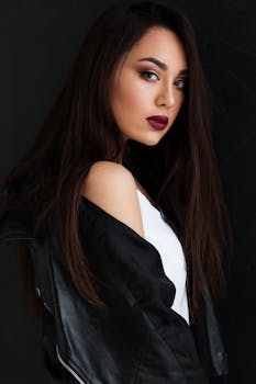 一位妆容醒目的年轻女子，身着黑色皮夹克，姿态优雅