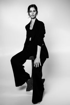 Stylish black and white portrait of a woman in a suit, showcasing elegance and modern fashion.