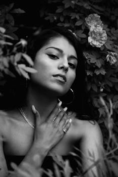 这幅迷人的黑白肖像画描绘了一位被鲜花包围的女人，散发着优雅与美丽