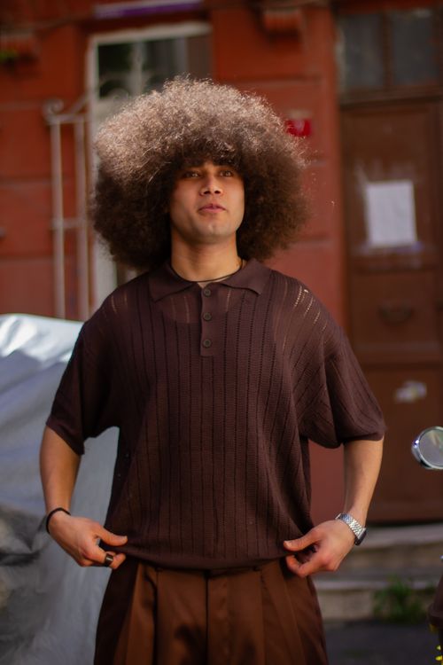 Free Man with afro hairstyle posing outdoors in an urban area. Stock Photo