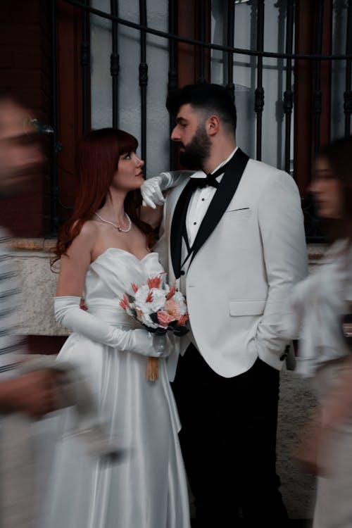A bride and groom in a wedding dress and tuxedo