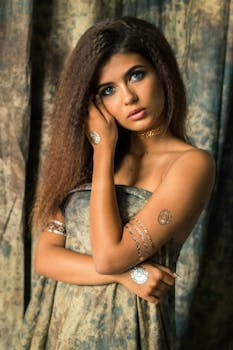 一位卷发、佩戴黄金珠宝的美丽女人在工作室拍照