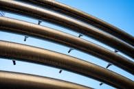 晴朗的蓝天下，金属管道的特写镜头呈现出一种现代而未来主义的外观