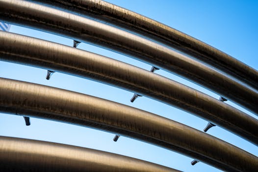 晴朗的蓝天下，金属管道的特写镜头呈现出一种现代而未来主义的外观