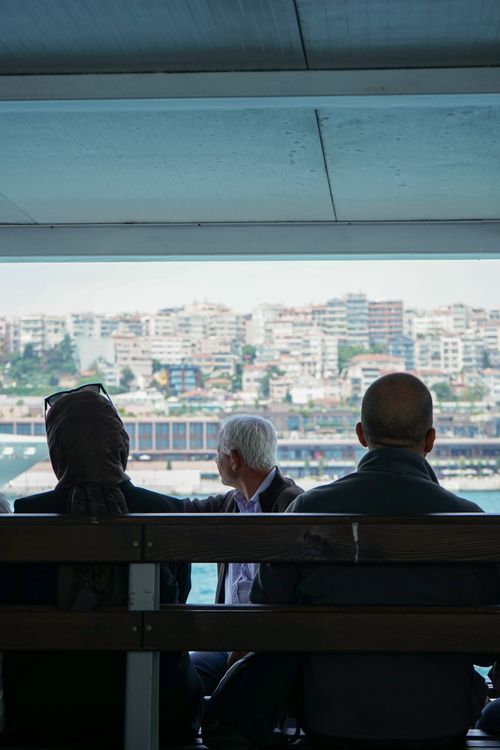 Free Passengers on a ferry with an urban cityscape view in the background. Stock Photo