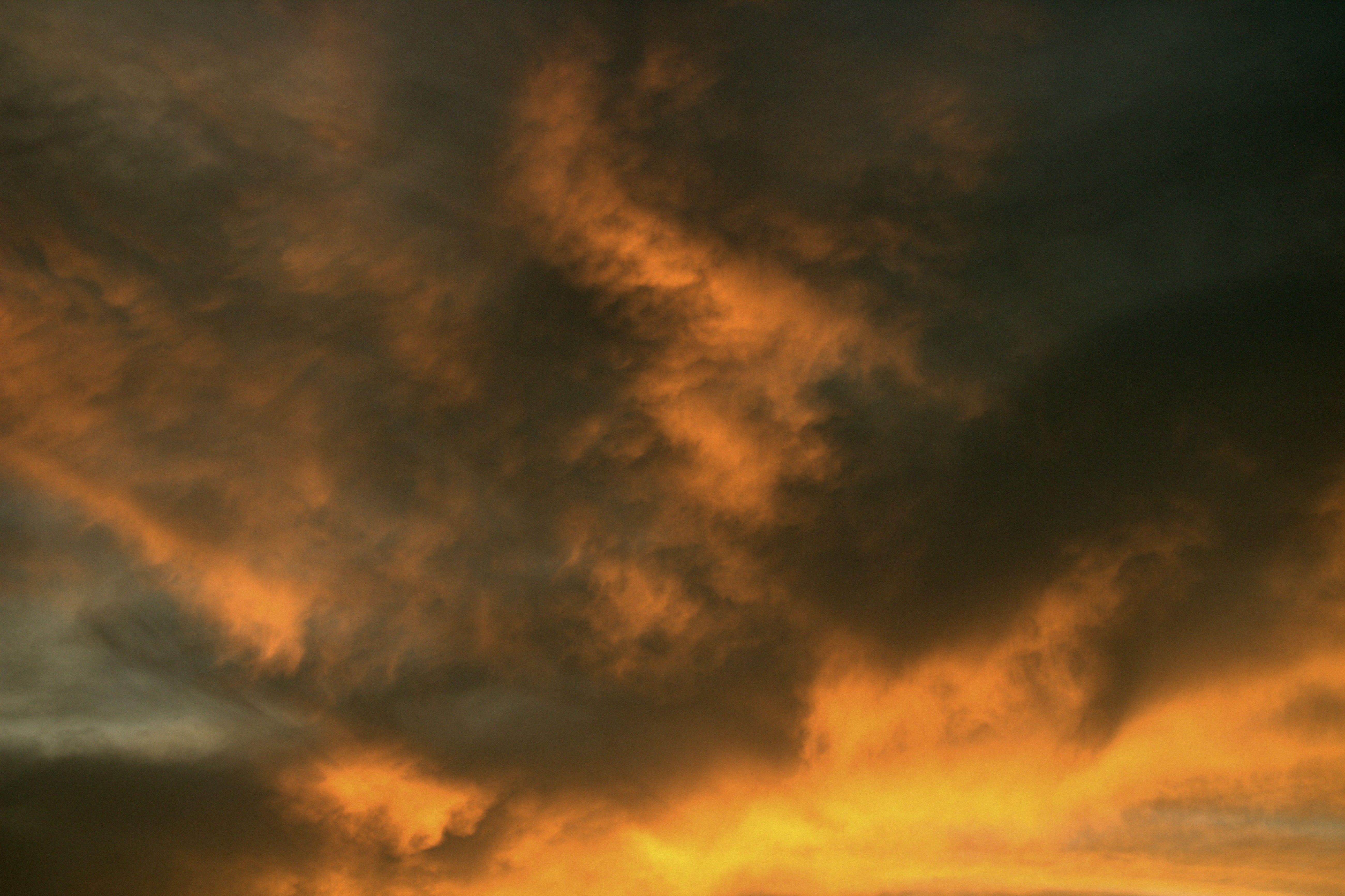 A plane flying through the sky with a cloudy sky · Free Stock Photo