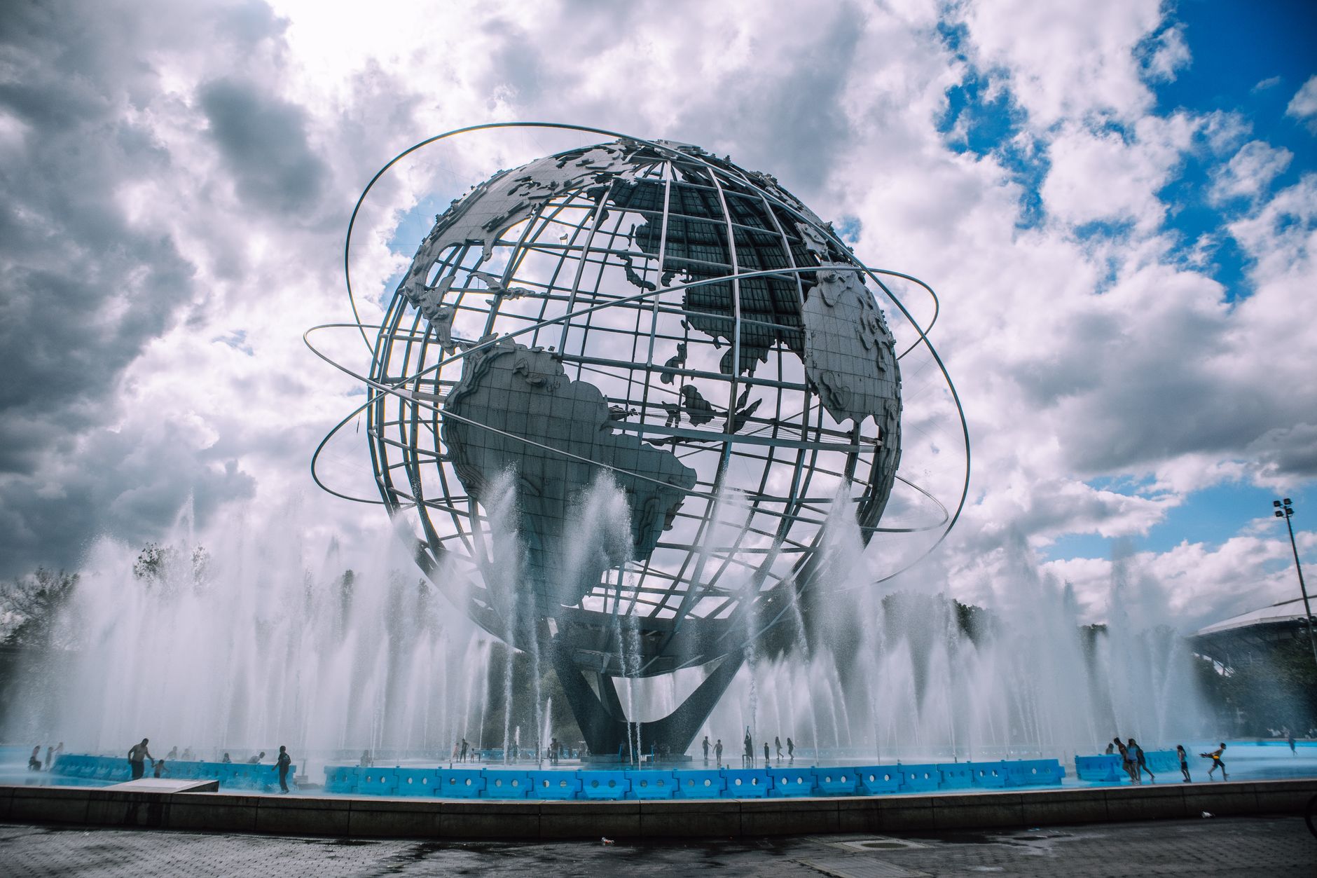 The iconic Unisphere monument in Flushing Meadows, New York, framed by a dynamic fountain display.