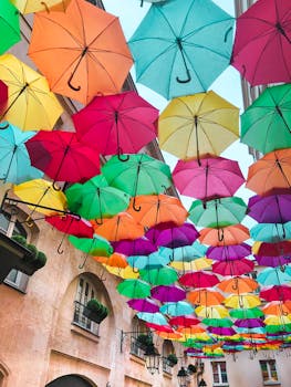 色彩缤纷的雨伞悬挂在古色古香的街道上，营造出生动的户外装饰