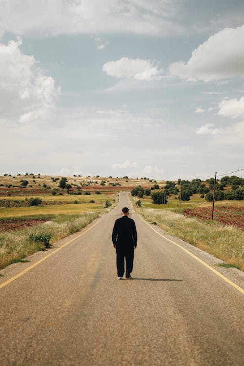 Man Walking on Road in Countryside