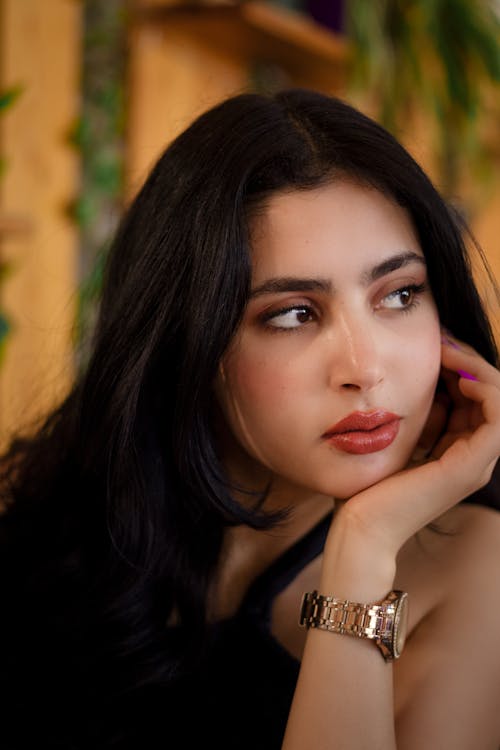 A woman with long black hair and a watch