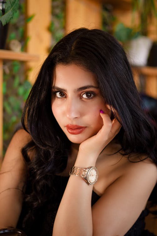 A woman with long black hair and a watch