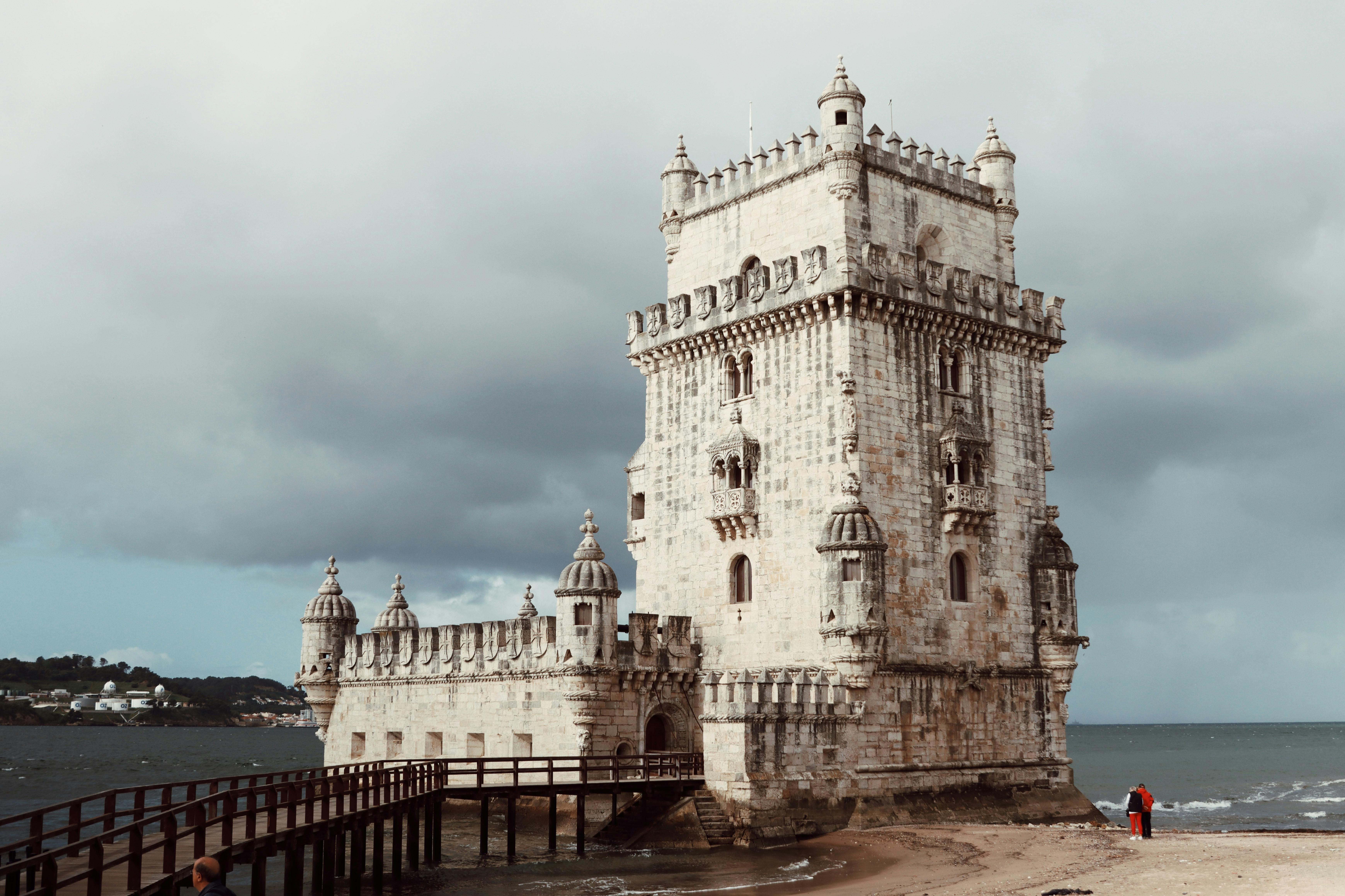 A captivating view of Belem Tower under a moody sky, showcasing its Gothic architecture.