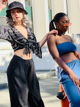 Two women posing confidently in stylish outfits during a sunny outdoor photoshoot in Portland.