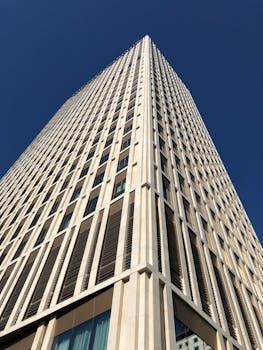 低角度镜头令人印象深刻，它捕捉到了一座现代摩天大楼，背景是清澈的蓝天，非常适合建筑主题