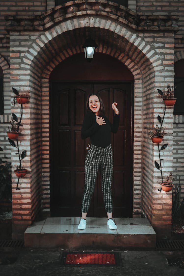 Photo Of Woman Standing In Front Of Wooden Door