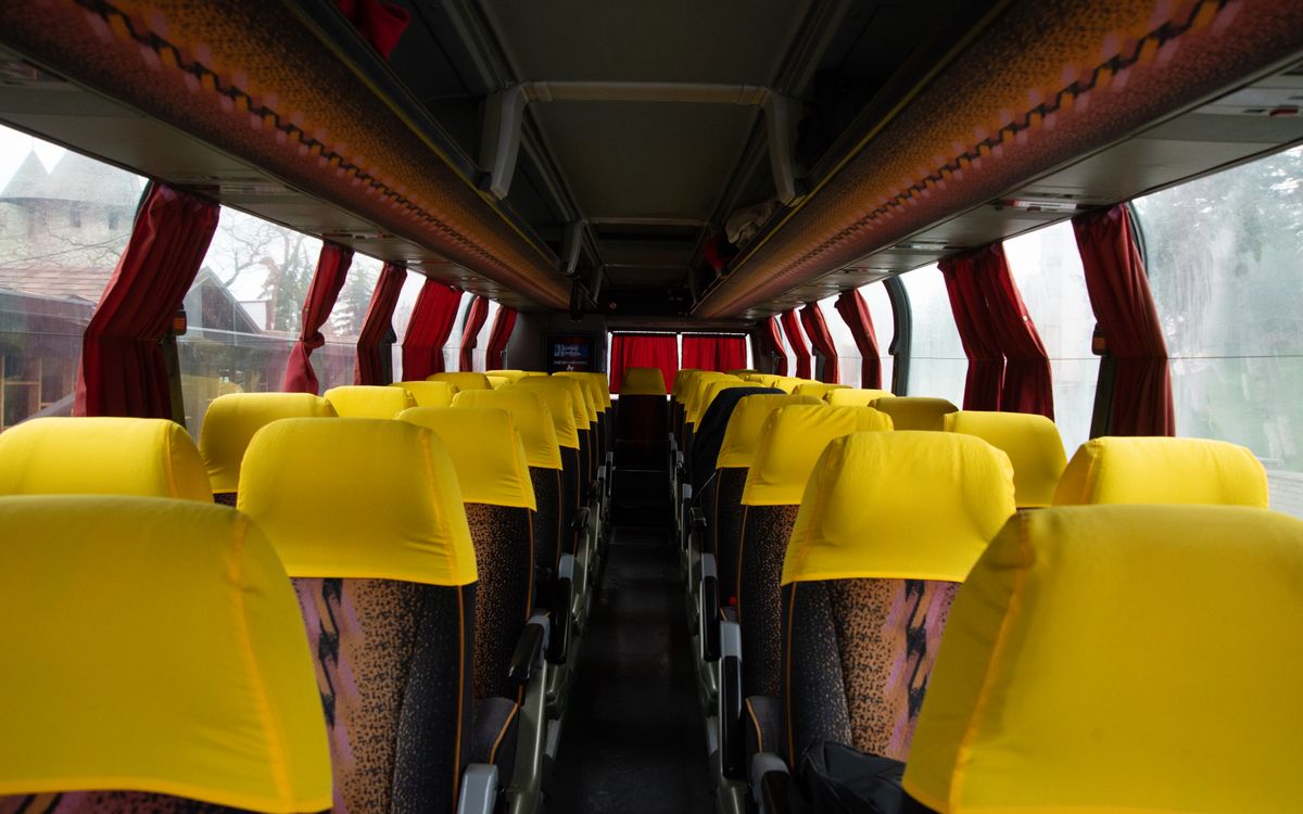Spacious bus interior featuring bright yellow seats and red curtains, ideal for travel and transportation imagery.
