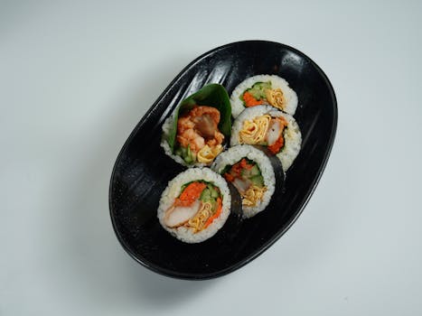 Close-up of assorted sushi rolls with fresh ingredients served on a black plate.