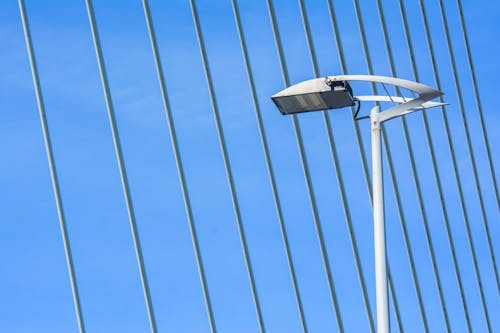A street light on a bridge with a blue sky