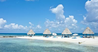 Palapas on a Belize beach — photo by Robert Schrader on Pexels