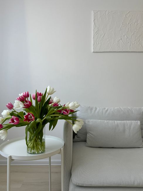 A stylish and elegant living room featuring a tulip bouquet in a modern minimalist design.