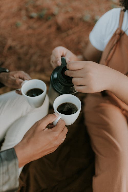 Woman and Man Hands with Coffee Cups and Pot