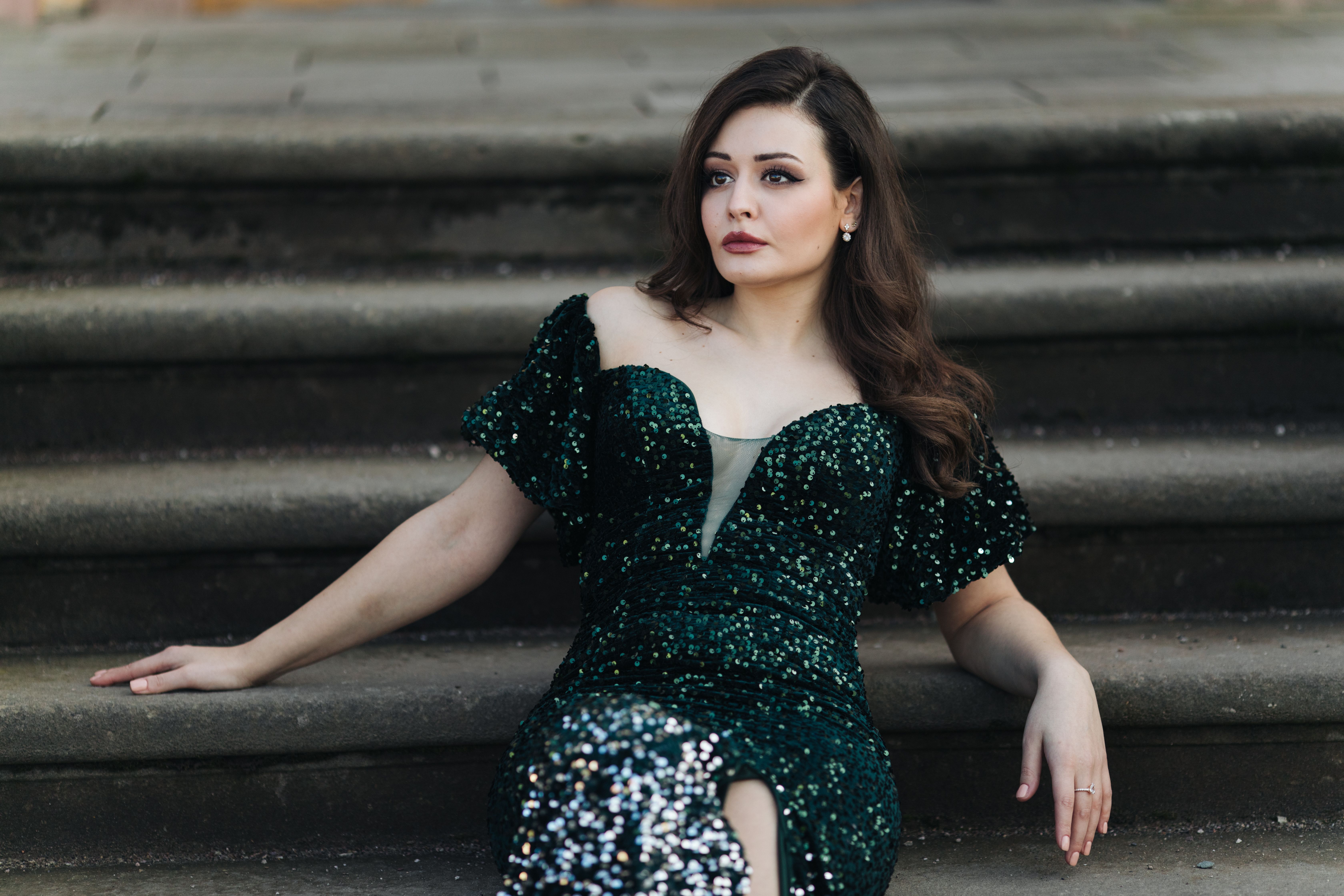 A woman in a green dress sitting on steps · Free Stock Photo