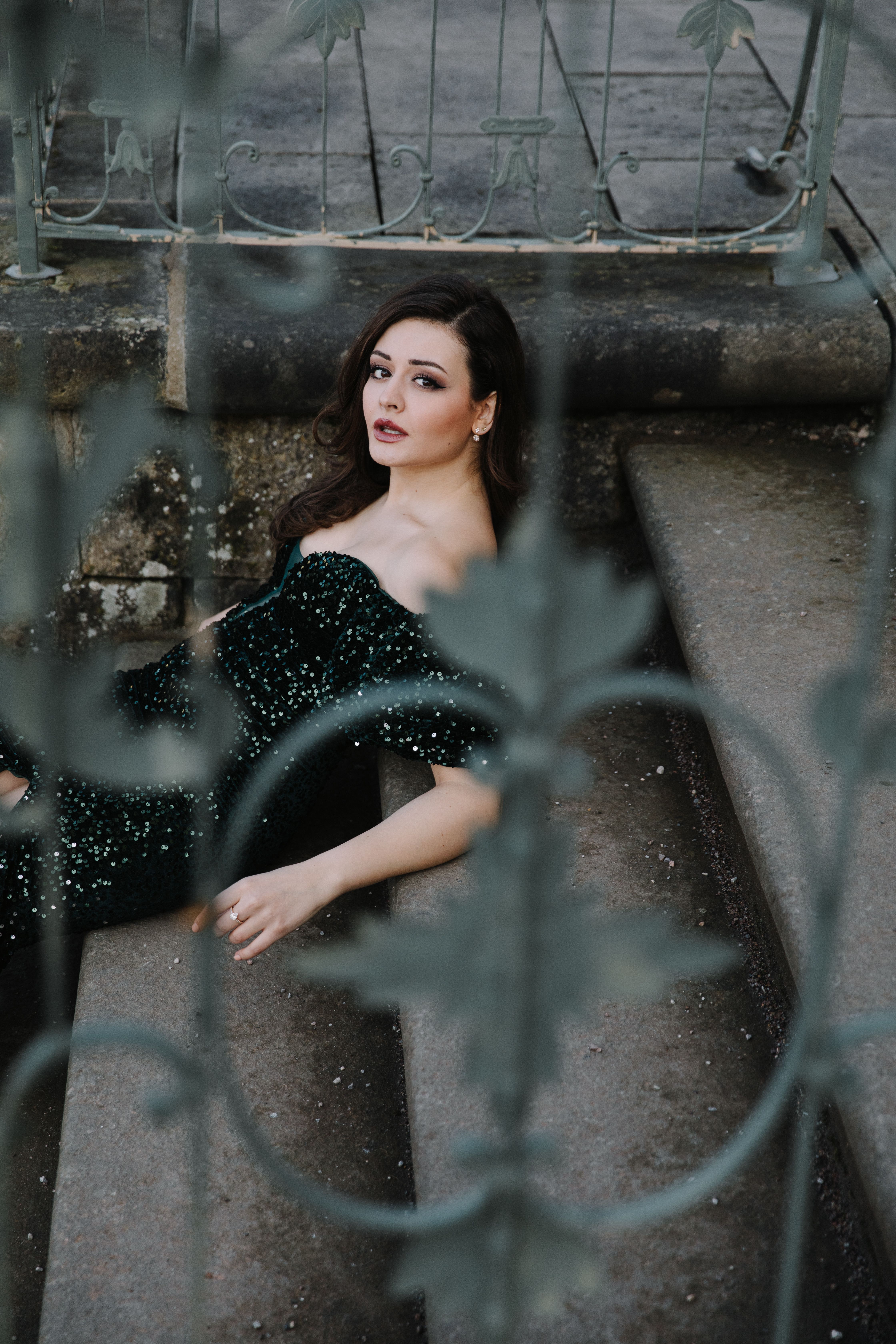 A woman in a green dress sitting on some stairs · Free Stock Photo