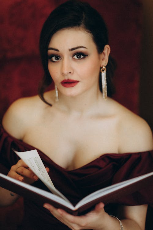 A woman in a red dress holding a book