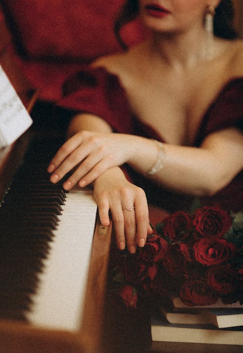 A woman in a red dress is playing the piano
