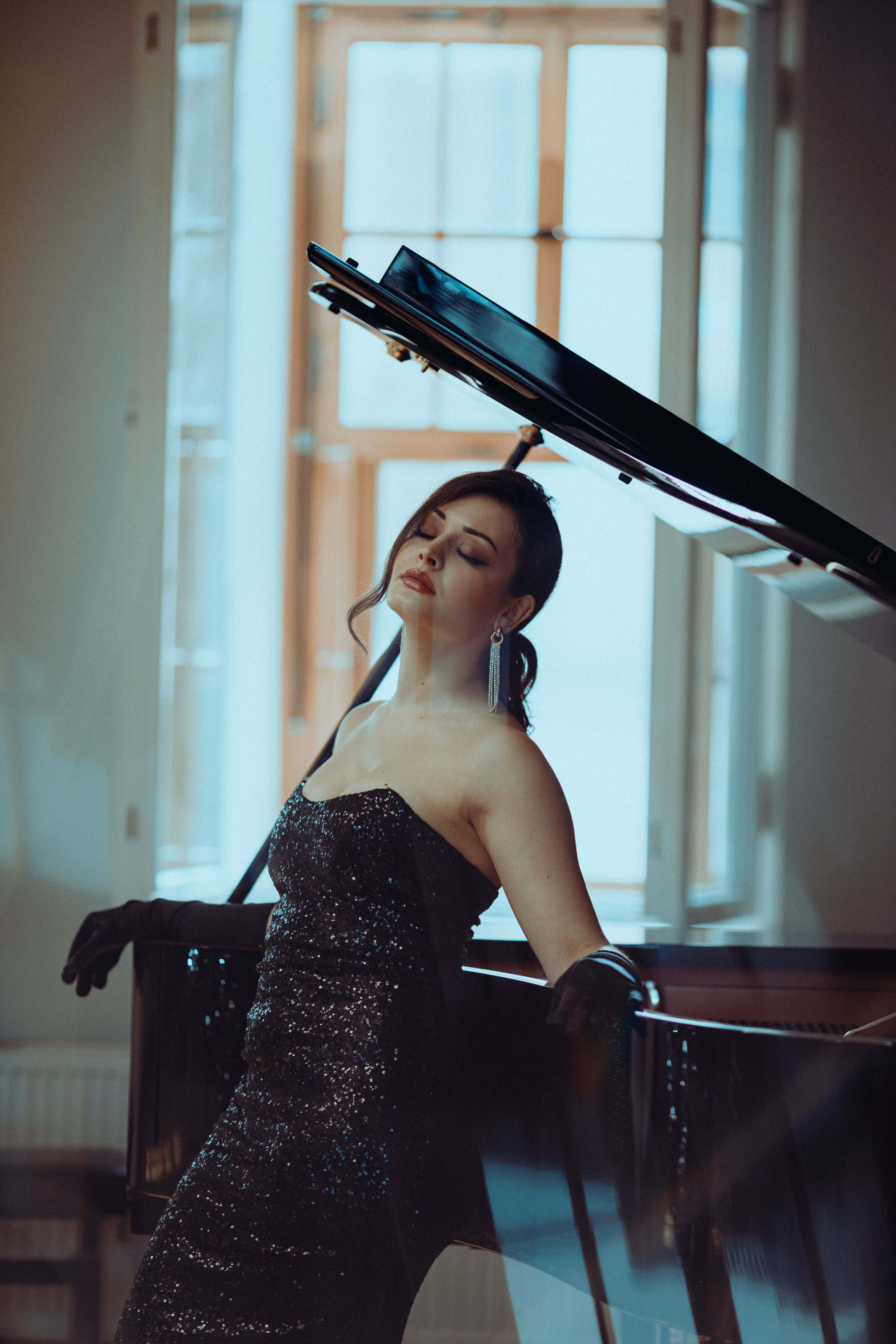 A singer beside a grand piano