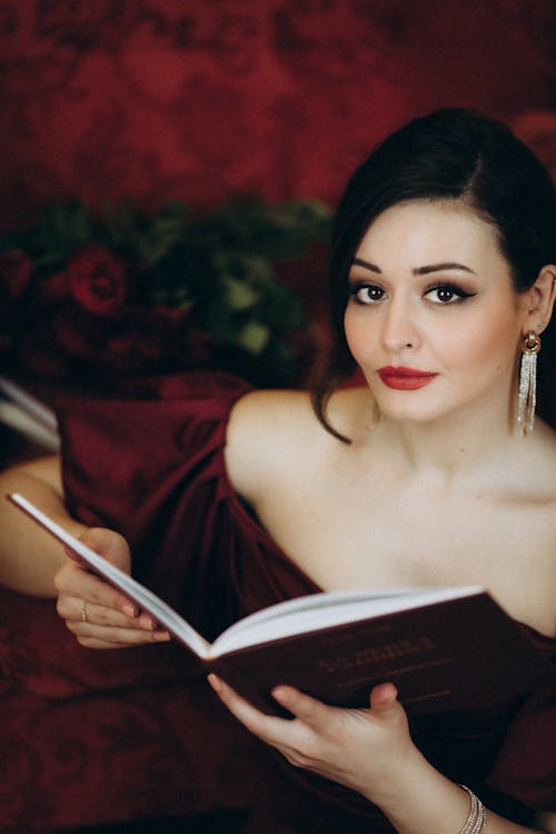 A woman in a red dress is reading a book