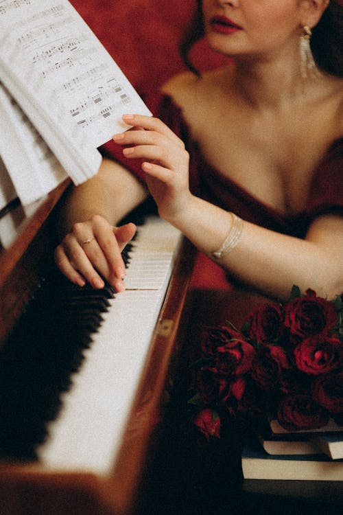 A woman in a red dress is playing the piano