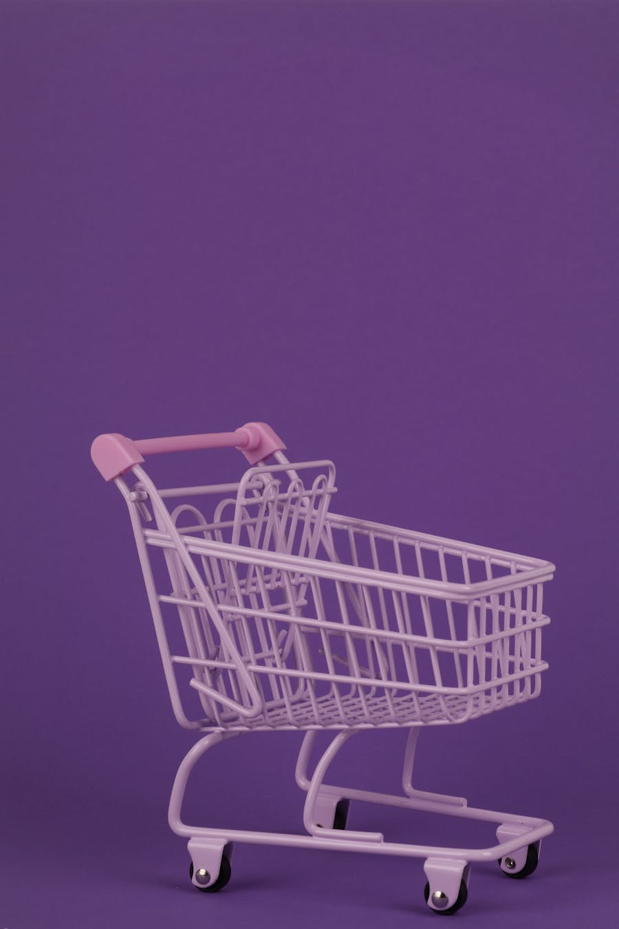 Vibrant purple shopping cart with ample copy space, perfect for retail themes.