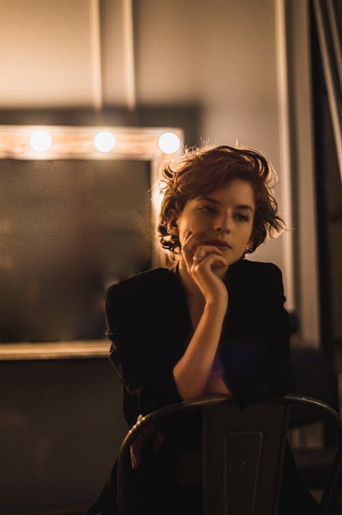 Photo of a woman sitting backwards on a metal chair