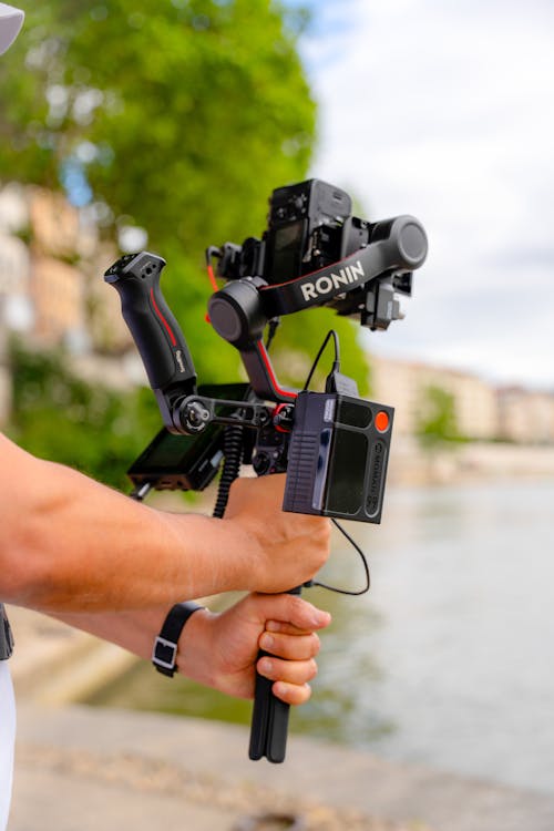 A person holding a camera and a tripod