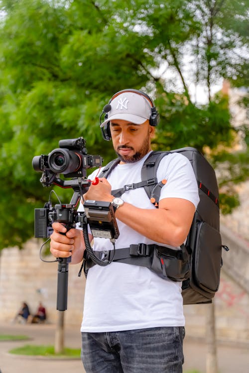 A man with a camera and backpack holding a camera