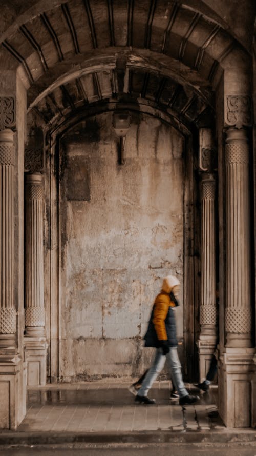 Man Walking in Front of an Arch 