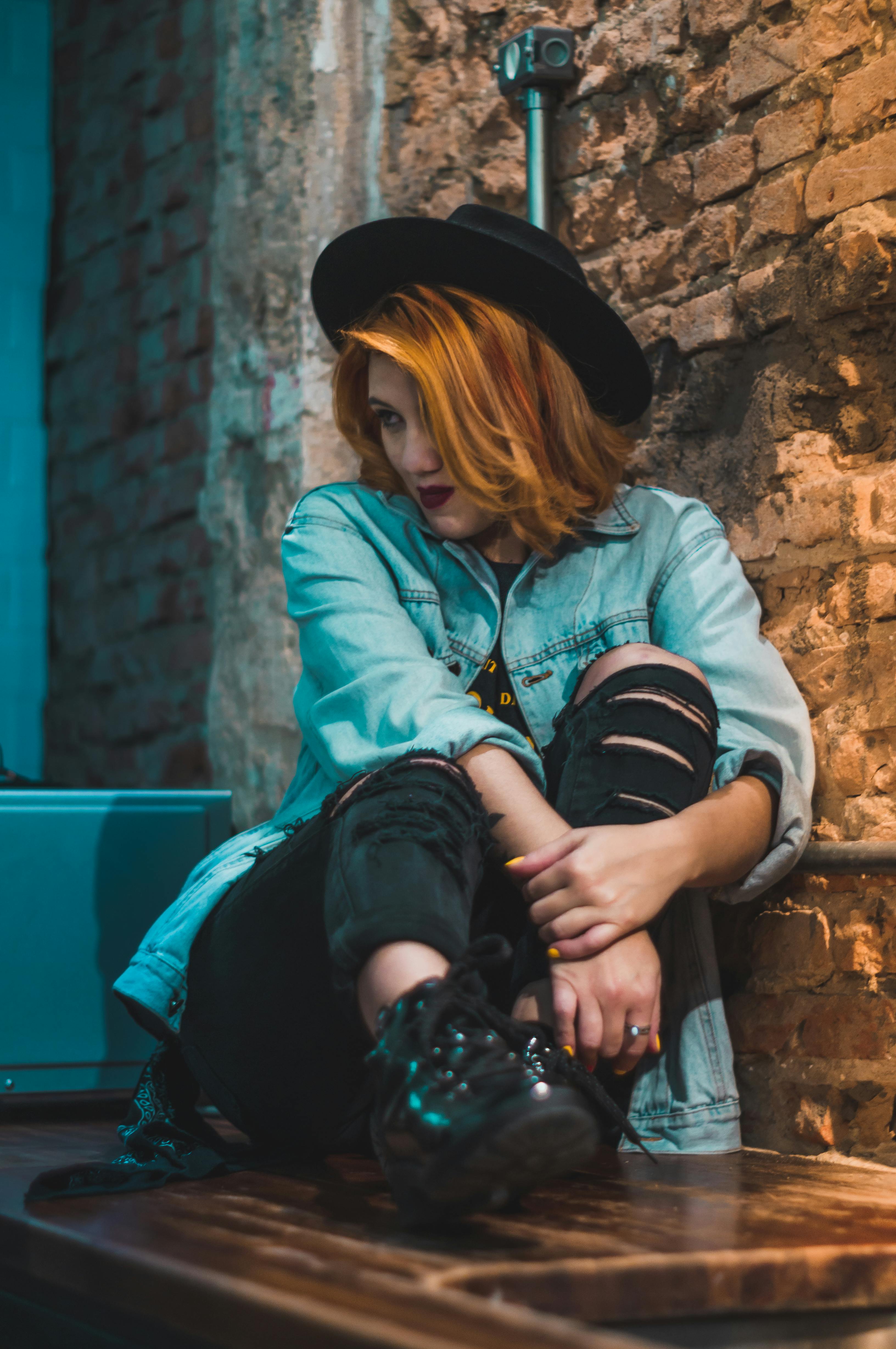 gratis Foto Van Een Vrouw Die Een Blauwe Spijkerjasje Naast De Muur Draagt Stockfoto