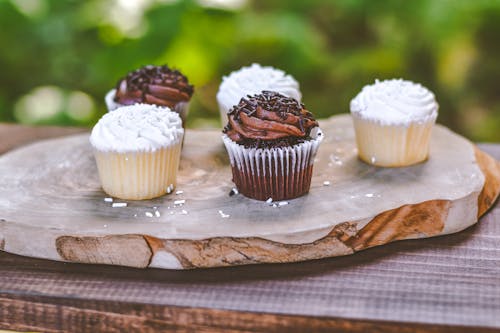 Foto De Cinco Cupcakes Em Uma Tábua De Madeira
