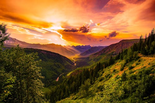 Green Mountain Near River Under Cloudy Sky during Daytime