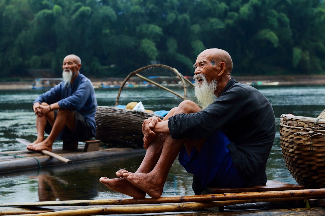 무료 강둑에 앉아 두 남자 스톡 사진